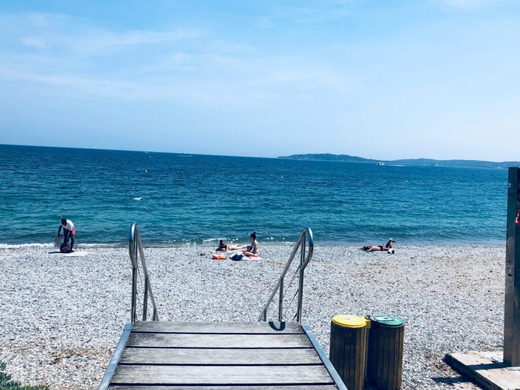 Kystidyl i Sainte-Maxime med småsten, blåt hav og afslappet feriestemning.